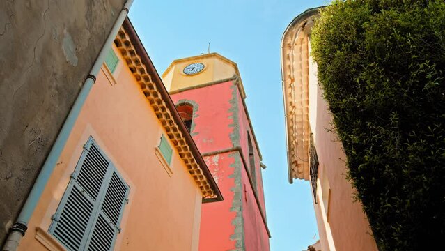 Beautiful colorful old tower clock in Saint Tropez village. Famous tourist destination in Cote d'Azur, France with a church tower.