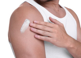 Man applying sun protection cream onto his shoulder against white background, closeup