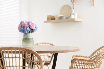 Rolgordijnen Vase with hydrangea flowers on wooden table in stylish dining room © New Africa