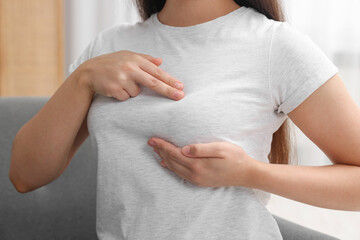 Woman doing breast self-examination at home, closeup