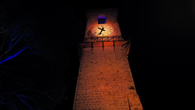 Clock and bell tower of Church of Notre Dame D'esperance at night in Cannes. Colorful famous landmark lit up at resort town on the French Riviera.