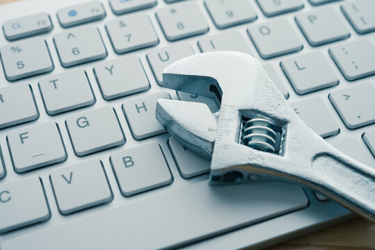 Adjustable wrench on keyboard background. Customer online service center for troubleshooting quick support warranty claim concept. Computer technology product, laptop, desktop, notebook, internet.