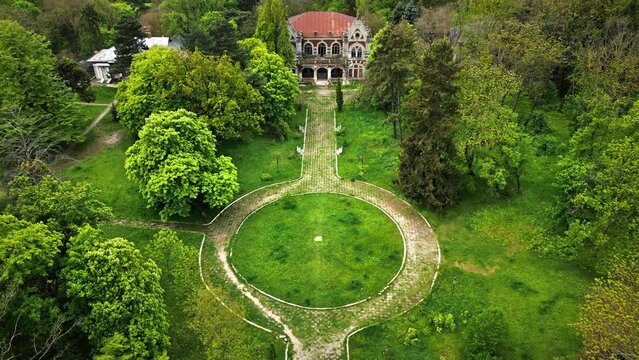 Drone view of the Pommer Mansion in Taul, Moldova. Old abandoned building with greenery around it and garden in front of it