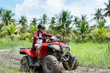 Quad bike in dust cloud, sand quarry on background. ATV Rider in the action.