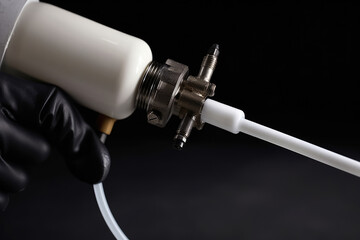 Extreme close-up of adhesive gun nozzle dispensing sealant onto a surface