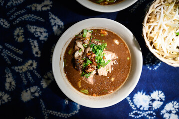 Rice noodles soup with pork and vegetables, Thai boat noodles style, Table top view