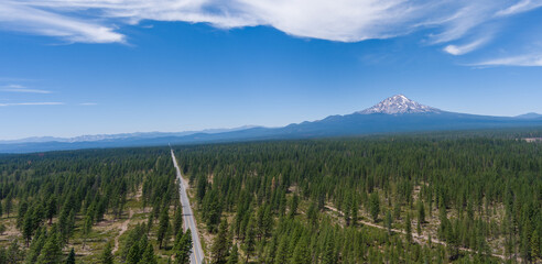 Aerial Panoramic View of Mt. Shasta with a partly cloudy blue sky.