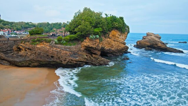 Basta Rock iconic bridge by Rocher de la Vierge in Biarritz town city, France. People tourists walk by a Beautiful rocky bridge on the seashore of the elegant royal town Biarritz.