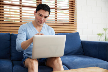 Fototapeta premium young handsome man using laptop computer for work at home