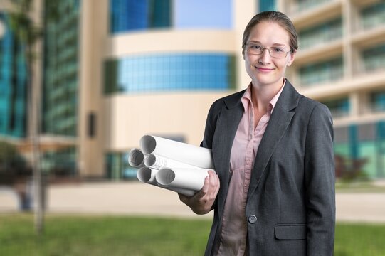 Portrait of confident young woman, standing with papers
