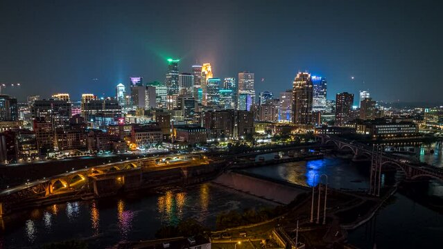 Drone night hyperlapse over Mississippi river of illuminated Minneapolis skyline