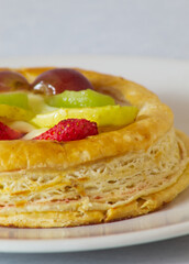 Tarta de frutas individual sobre un plato blanco y fondo gris