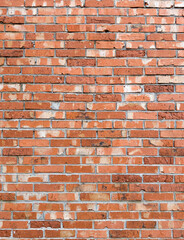 An orderly arrangement of red bricks, neatly and naturally stacked, which despite being old, still stands firm