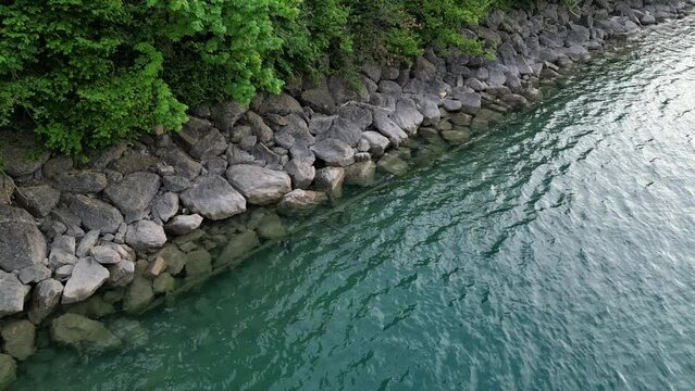 Mesmerizing calm relaxing peaceful scene of lake wavy waters reaching rocks on shore