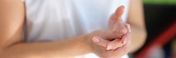 Close-up of woman applying cream to her hand.