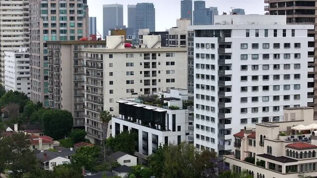 Aerial view rising above Wiltshire corridor high rise apartments to reveal Century city Los Angeles skyline