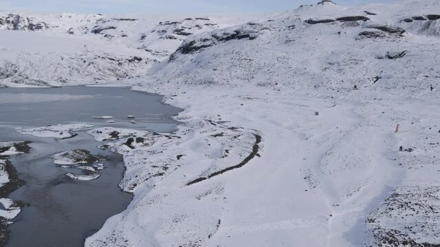 Establishing aerial shot of a group of parachuters landed within a snowy Iceland valley