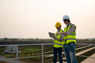 Fototapeta na wymiar Renewable energy concepts.Electrical engineers are using laptops to monitor the operation of the solar rooftop.Engineering team working operation and maintenance in solar power plant in solar