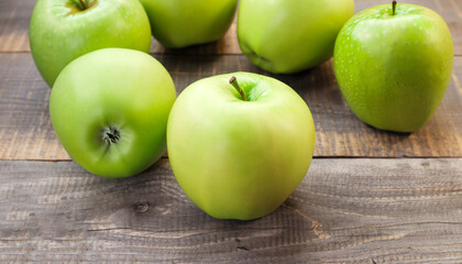 Ripe green apples on wooden background
