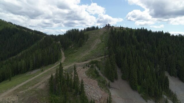 Aerial above ski resort in northern Idaho in summer showing ski runs and pine trees