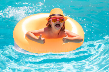 Summer travelling. Child boy in swimming pool with inflatable ring. Kids swim in water pool on summer vacation. Swim for child on float. Beach sea and water fun.