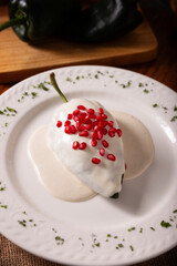 Chile en Nogada, Typical dish from Mexico. Prepared with poblano chili stuffed with meat and fruits and covered with a walnut sauce. Named as the quintessential Mexican dish for national holidays.