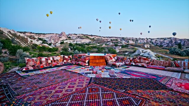 The beautiful and charming terrace in Cappadocia. The stylish rooftop terrace and hot air balloons in the background at sunrise. 8K
Travel concept