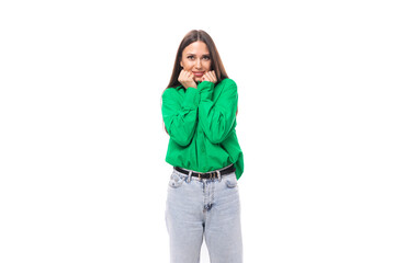 portrait of a confident smiling young european brown-eyed female model with well-groomed black hair and makeup dressed in a green shirt