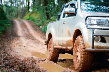 Offroad travel and driving concept, Wheel closeup in a countryside landscape with a muddy road,...