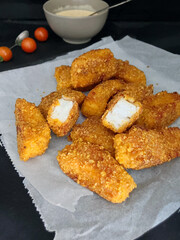 Homemade fish nuggets on grease proof paper with a dark background