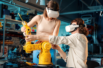 Young man and woman in VR glasses doing experiments in robotics in a laboratory
