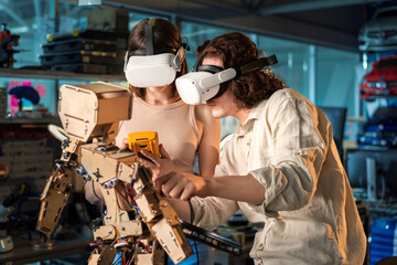 Young man and woman in VR glasses doing experiments in robotics in a laboratory