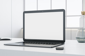 Close up of white office desktop with empty laptop screen, supplies and other objects. Blurry concrete wall and window with city view in the background. Mock up, 3D Rendering.