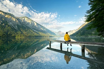 Fotobehang Auszeit genießen in den Bergen, Frau sitzt auf kleinen Steg © Jenny Sturm