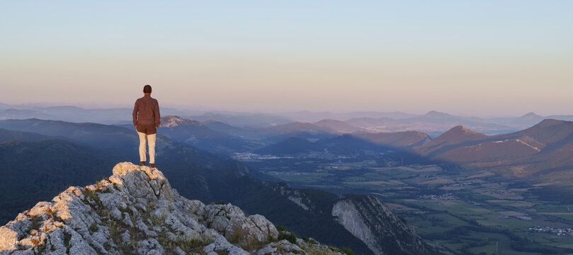 Man at sunset in the Sierra de Aralar with the mountains of Navarra in the background. © poliki