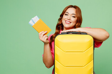 Traveler young overweight woman wear casual clothes hold bag passport ticket isolated on plain...