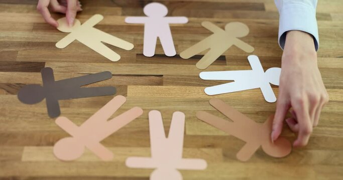 Paper different human figures making circle on table. Concept of diversity and inclusion