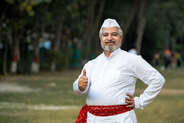 Indian man in traditional wear and showing thumps up - obrazy, fototapety, plakaty