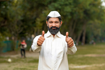 Indian or marathi man in traditional wear and showing thumps up.