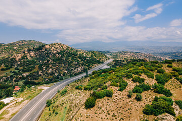 Fototapeta na wymiar Highway vehicles pass scenic mountain landscape, aerial view