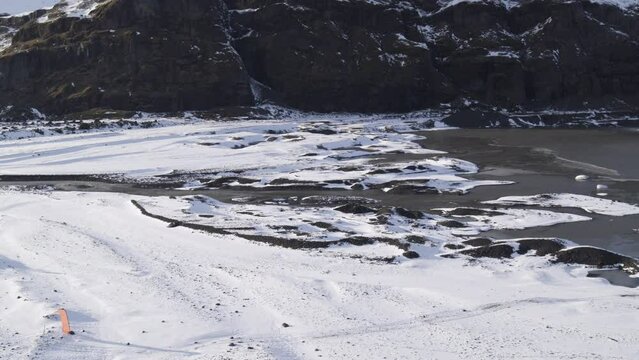 Aerial establishing shot of parachuters landed within a frozen Icelandic valley