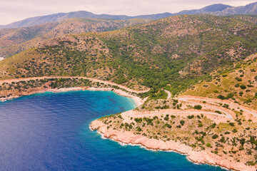 Obraz premium Scenic winding road between hills and sea coastal landscape, aerial shot