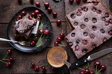 Fototapeta na wymiar Sheet cake with chocolate and cherries served with dalgona coffee on wooden table. Top view