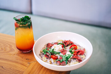 meat potato salad with tomatoes and pieces of beef on a plate in a cafe. light summer salad with potatoes and meat from a coffee house