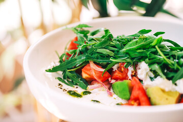 fresh salad with arugula and avocado on the table. refreshing salad with fresh herbs and vegetables