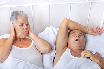 Schlafstörung durch schnarchen, älteres Paar im Bett
