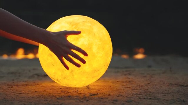 Happy woman close-up hands holding moon touching magic light glowing planet raises to night sky dusk evening. Modern mystery body part arm person, dark water river lake. Girl pray dream fairy art. 4k