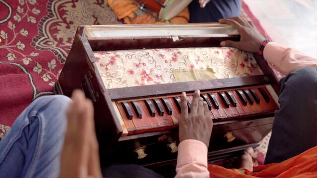 one man playing harmonium at temple