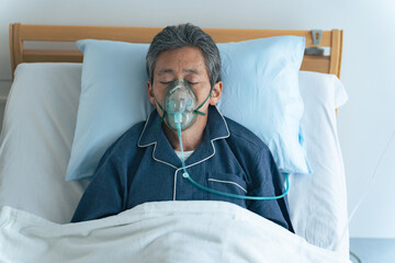 酸素マスクをつけてベッドに寝るシニア男性 - obrazy, fototapety, plakaty