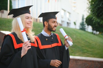 education, graduation and people concept - group of happy international students.